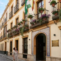 Análisis del sector del alojamiento: La experiencia de un hotel en el centro de Sevilla 1 Fachada de un hotel en el centro de Sevilla con elementos arquitectónicos tradicionales y balcones.