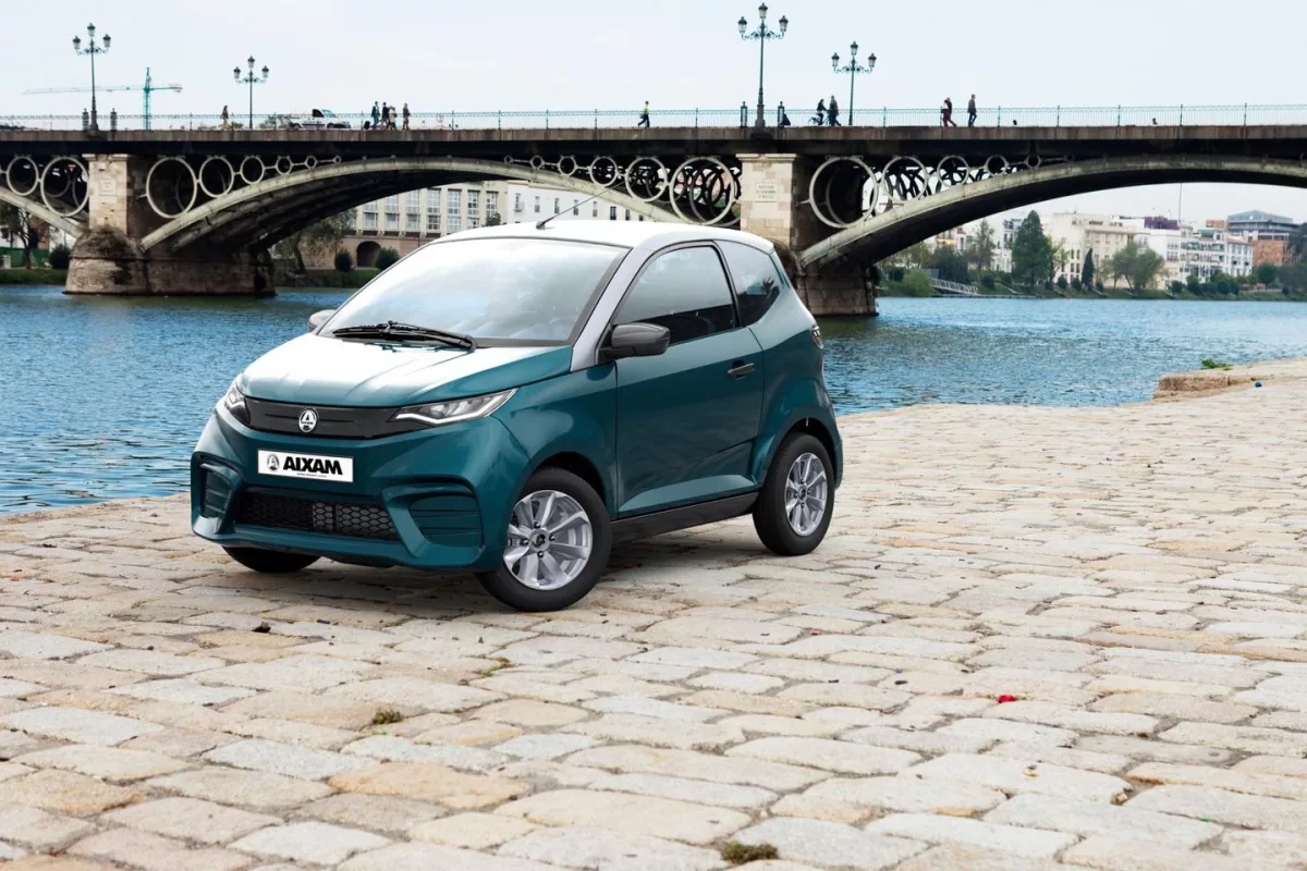 Recambios de coches de sin carnet en Sevilla: Guía para elegir repuestos compatibles sin errores de taller 1 Coche sin carnet de la marca Aixam aparcado junto al Puente de Triana, ideal para ilustrar la guía de recambios en Sevilla.